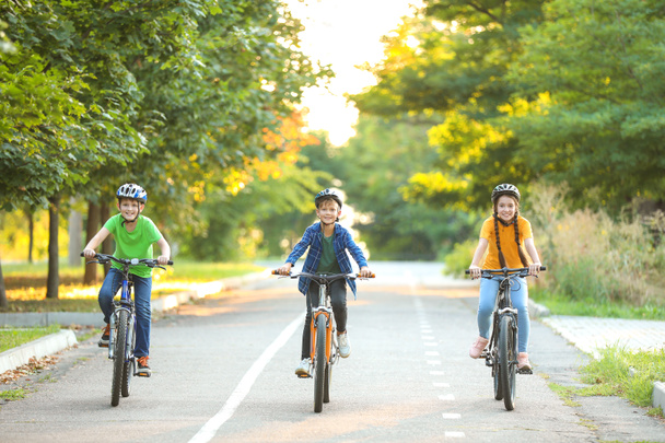 屋外で自転車に乗るかわいい子供たち - 写真・画像