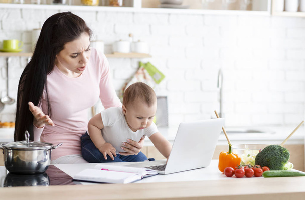 Madre sorprendida mirando a su bebé haciendo clic en el ordenador portátil
 - Foto, imagen