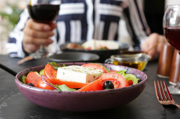 Teller mit leckerem griechischen Salat auf dem Tisch - Foto, Bild