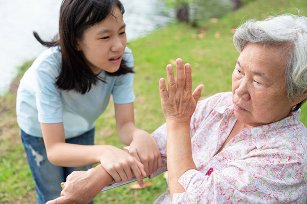 Несчастная азиатская девочка комфорт расстроен старший бабушка, женщина подросток подчеркнул, чтобы попытаться примириться или компромисс, пожилые люди, глядя в сторону избегая разговора с внучкой
 - Фото, изображение