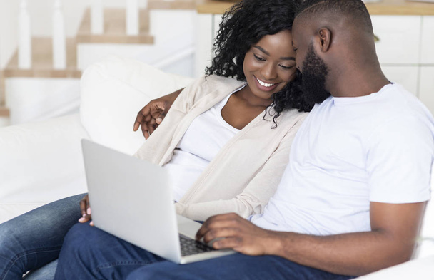 schwarzes Paar verbringt Wochenende zusammen und schaut Film auf Laptop - Foto, Bild