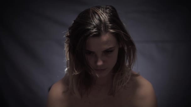 Häusliche Gewalt, eine verzweifelte Frau in Depressionen blickt in die Kamera und zaubert ein Lächeln ins Gesicht, ein gesellschaftliches Problem - Filmmaterial, Video