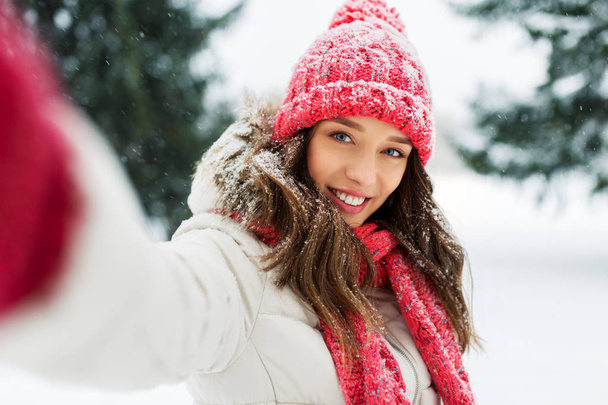 smiling woman taking selfie outdoors in winter - Фото, зображення