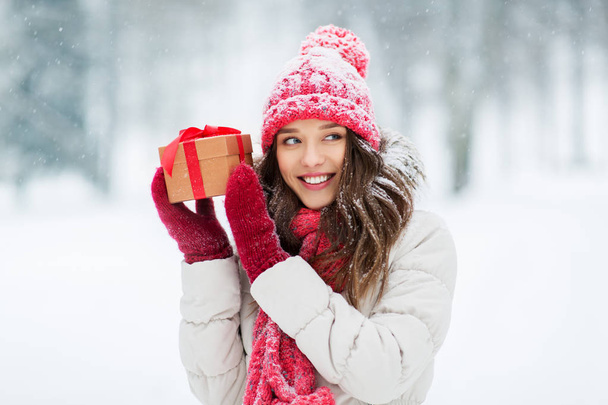 šťastná mladá žena s vánočním dárkem v zimě - Fotografie, Obrázek