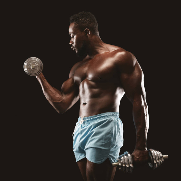 Retrato de fisiculturista preto fazendo único braço halteres curl
 - Foto, Imagem