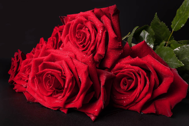 ein schöner Strauß roter Rosen mit schön geblühtem Blütenblatt - Foto, Bild