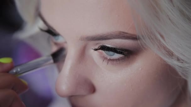 Blonde girl do professional makeup. - Materiał filmowy, wideo