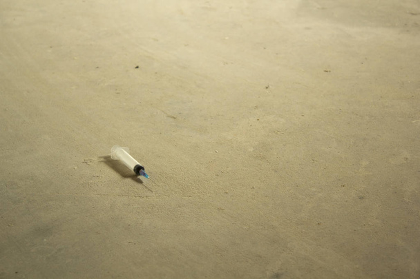 Seringue et aiguille sur le sol en béton
 - Photo, image