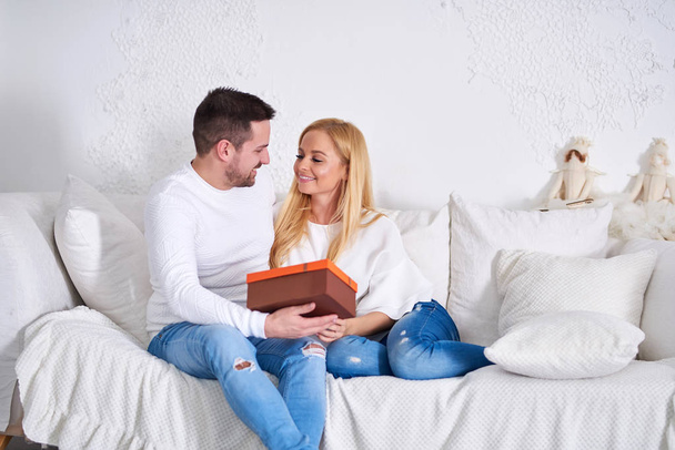 Couple on a sofa giving presents - Foto, imagen