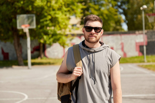 man with backpack at street basketball playground - Foto, afbeelding