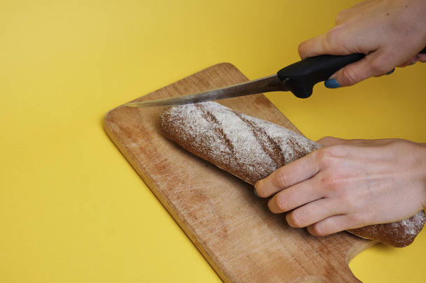 cropped shot of woman slicing fresh tasty rye bread   - Fotografie, Obrázek