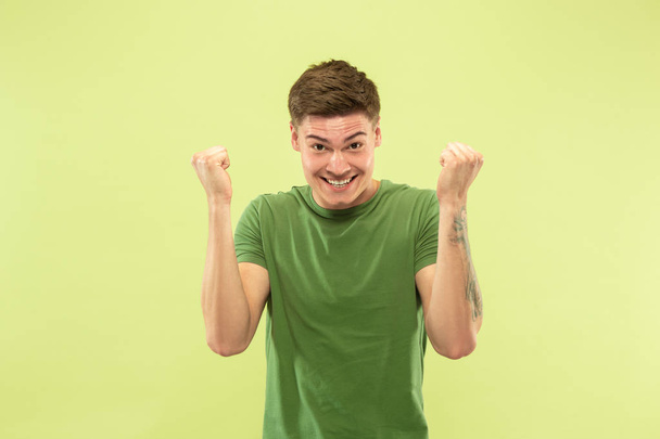 Caucasian young mans half-length portrait on green background - Photo, Image