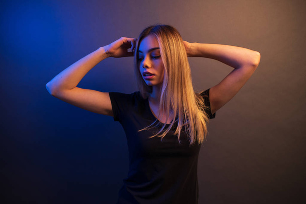 Sexy young blonde girl portrait over gray paper background in neon lights - Fotoğraf, Görsel