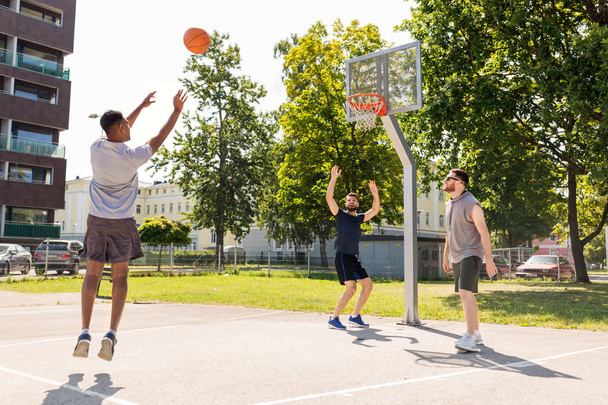 group of male friends playing street basketball - Фото, изображение