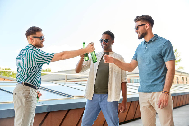 happy male friends drinking beer at rooftop party - Photo, Image