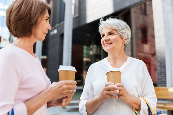 senior women with shopping bags and coffee in city - Foto, Bild