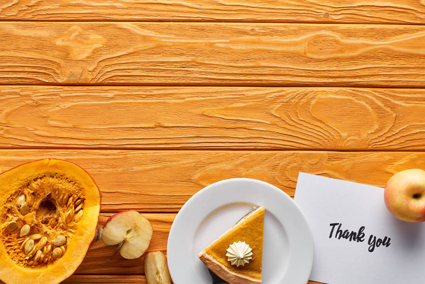 top view of pumpkin pie, ripe apples and thank you card on wooden table with copy space - Photo, Image