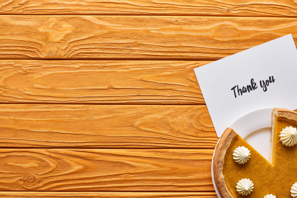 vista superior da torta de abóbora e cartão de agradecimento na mesa de madeira
 - Foto, Imagem