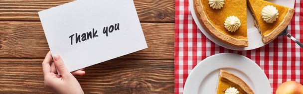 cropped view of woman holding thank you card near pumpkin pie on wooden rustic table - Photo, Image