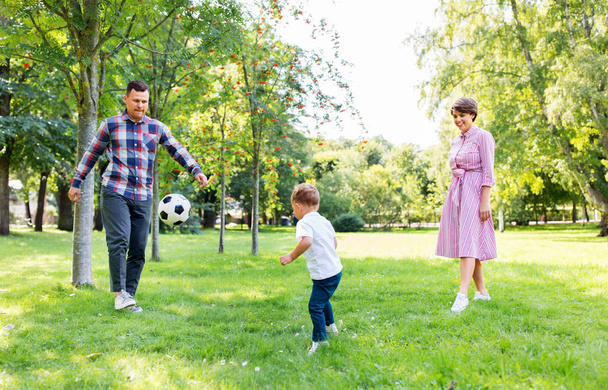 happy family playing soccer at summer park - Foto, Bild