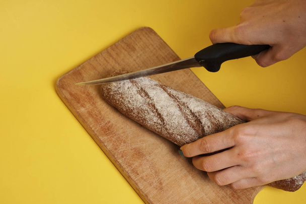 cropped shot of woman slicing fresh tasty rye bread   - Fotografie, Obrázek