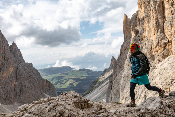 A young man in the mountains travels with a backpack. beautiful view of the mountain landscape of the Dolomites in Italy - Photo, Image