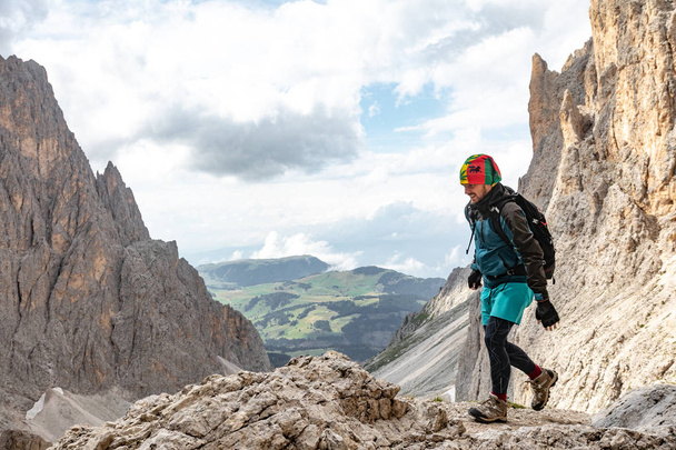 Een jongeman in de bergen reist met een rugzak. prachtig uitzicht op het berglandschap van de Dolomieten in Italië - Foto, afbeelding