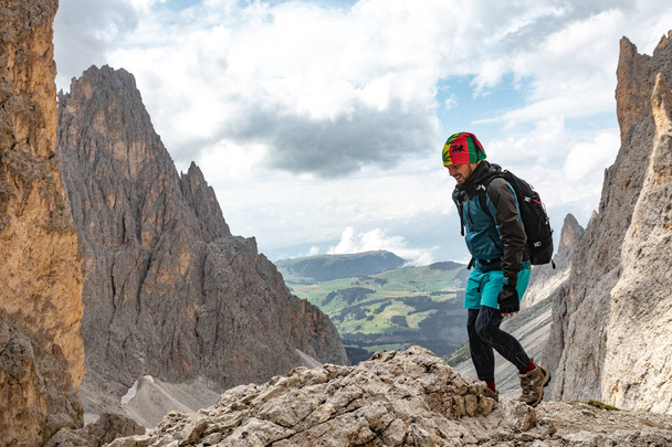 A young man in the mountains travels with a backpack. beautiful view of the mountain landscape of the Dolomites in Italy - Valokuva, kuva