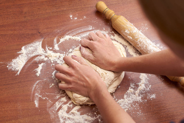 Close up hands of woman kneading a dough on a wooden board   - Photo, Image