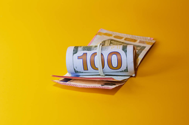 pack of dollars and euros money on yellow background - Foto, Imagem