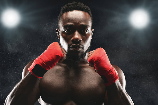 Un combattant concentré en défense pose sur un ring de boxe
 - Photo, image