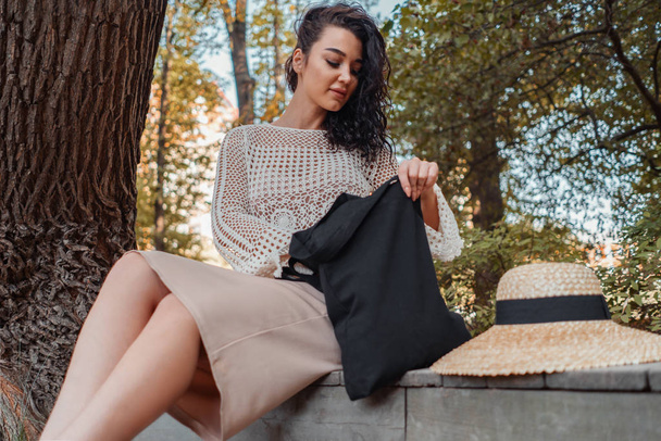 Woman with black blank bag outdoors in park. Place for Empty space. Copy space. Eco friendly. - Photo, image