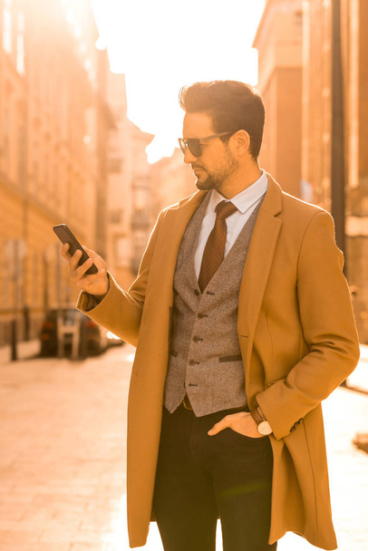 A handsome elegant man using his smartphone - Fotó, kép