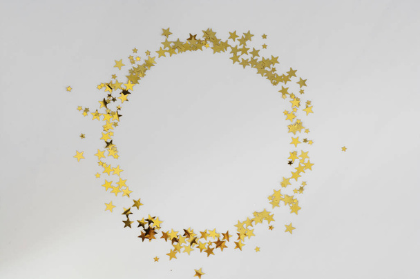 Golden glitter frame circle, confetti stars isolated on white background. Christmas, party or birthday background. - Фото, зображення