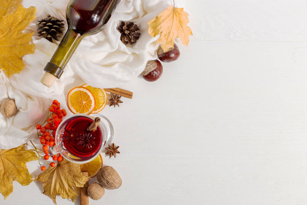 A cup of mulled wine with spices, bottle, scarf, spices, dry lea - 写真・画像