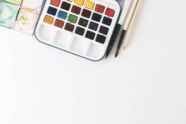 Watercolor paints and paint brushes for painting on work table. Creative art flat lay. Copy space. - Φωτογραφία, εικόνα