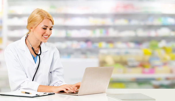 Pharmacien utilisant ordinateur portable à la pharmacie
. - Photo, image