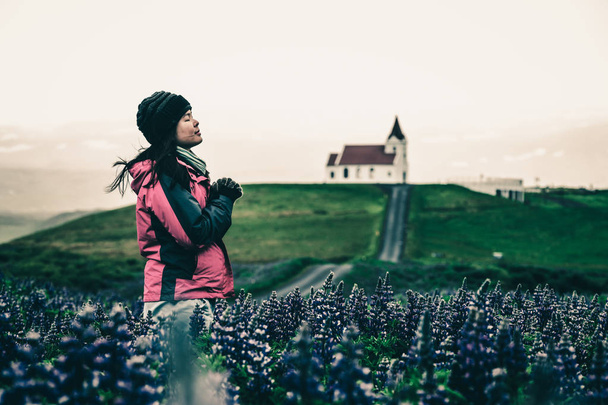 Reiziger in IJsland. Kerk en lupine bloemen. - Foto, afbeelding