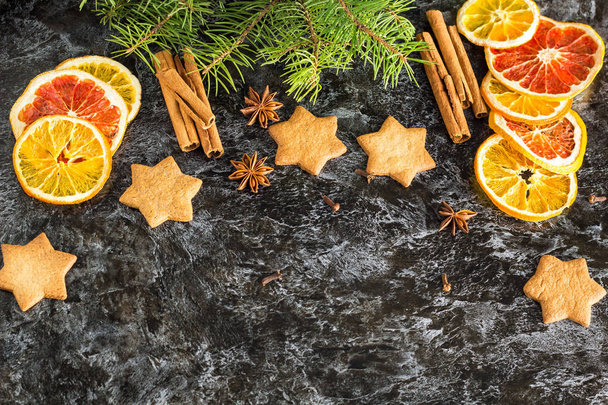 Weihnachten Hintergrund mit Tanne trocken orange Zimtanis und Stern von Lebkuchen auf dunklem Hintergrund. - Foto, Bild