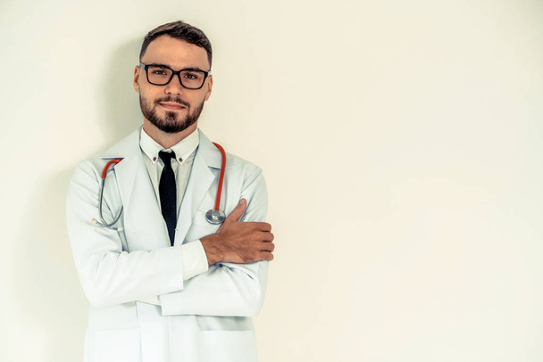 Young doctor with arms cross on white background. - Photo, Image