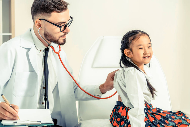 Доктор вивчає маленьку щасливу дитину в лікарні
. - Фото, зображення