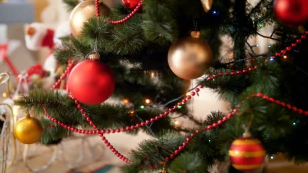 Primer plano 4k metraje de hermosas bolas brillantes y luces que cuelgan en el árbol de Navidad decroated en la casa. Perfecto para celebraciones de invierno y días festivos
 - Metraje, vídeo