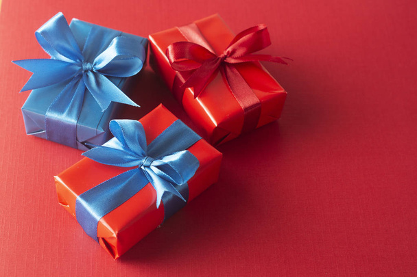 Blue and red gift boxes with red ribbon and bow isolated on red background, top view. Christms, party concept. - Fotografie, Obrázek