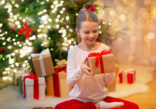 smiling girl with christmas gift at home - Fotografie, Obrázek
