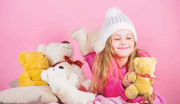 Kid little girl play with soft toy teddy bear pink background. Softness is key. Child small girl playful hold teddy bear plush toy. Bears toys collection. Teddy bears improve psychological wellbeing - 写真・画像