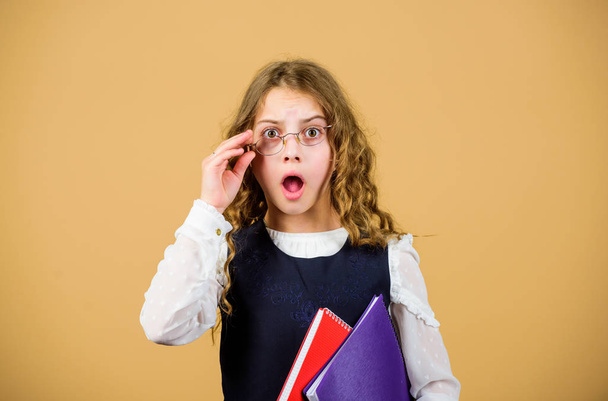 Check knowledge. Final exam coming. Girl hold textbook folder test. School exam concept. Preparing to exams in library. Small child formal wear. Prepare for exam. Formal education and homeschooling - Fotoğraf, Görsel