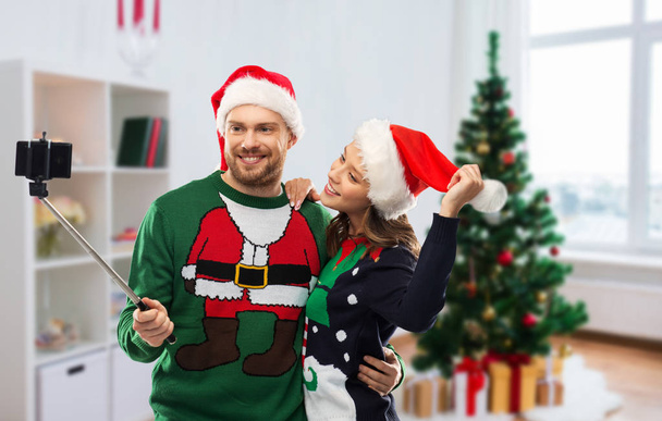 happy couple in christmas sweaters taking selfie - Foto, Imagen