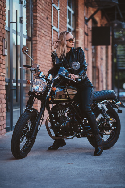 Krásná ženská biker se pózuje na fotografa s motorkem - Fotografie, Obrázek