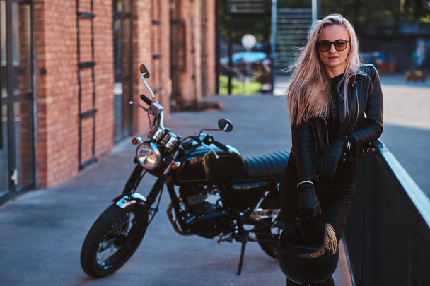 Szép női motoros pózol a fotós vele motorkerékpár - Fotó, kép