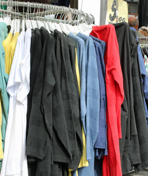 de nombreux vêtements exposés dans un marché de rue
 - Photo, image
